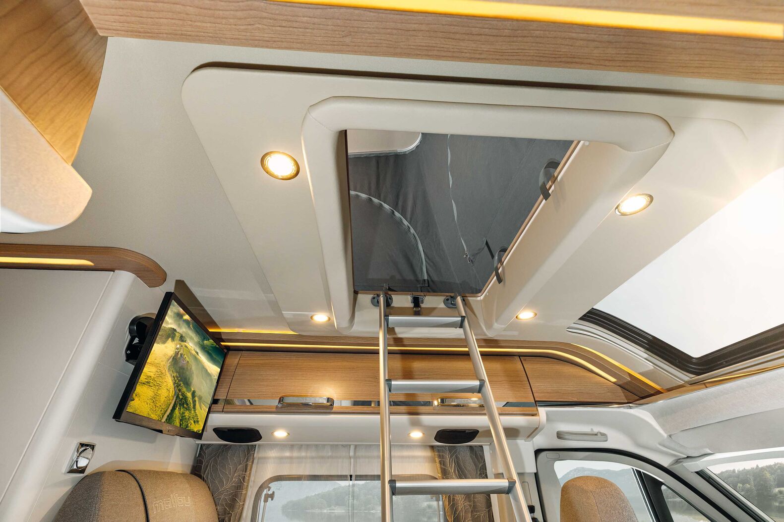 Malibu Van family-for-4: Maximaler Platz für die Familie mit Kindern, Paare mit Enkeln, Ferien mit Freunden – der Malibu Van family-for-4 bietet zwei grosse Schlafräume. Das exklusive Aufstelldach in Sandwich-Hybridkonstruktion hat Malibu selbst entwickelt und gefertigt. Die aufwendige Sandwichkonstruktion des Hybrid-Aufstelldachs besteht aus dem robusten GFK-Dachbelag «Protect» zum Schutz gegen Hagel und andere Beschädigungen von aussen. Der Dachaufbau überzeugt durch einen Isolierkern aus RTM-Hartschaum und der Dachinnenseite aus Aluminium. Ein atmungsaktiver Mikrofaserbelag auf der Dachinnenseite sorgt für Wohnlichkeit. Eine geschickte Kinematik aus Scheren-Scharnieren im Fussbereich und Gasdruckfedern vorn hebt das Dach beim Öffnen an, der grosse Aufstellwinkel sichert viel Kopffreiheit. Oben wartet ein stattliches Bett im Format 200 x 135 cm mit einer hochwertigen Kaltschaummatratze. Das Aufstelldach steht als Modellvariante family-for-4 für zahlreiche Malibu Van zur Verfügung.