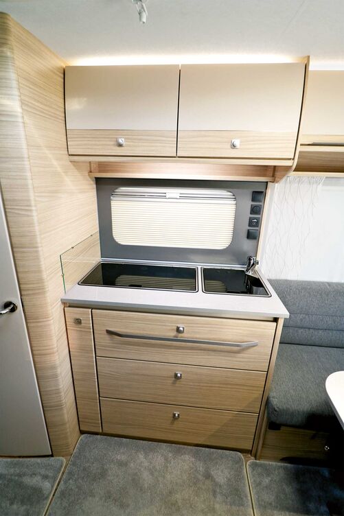 Très fonctionnelle, la cuisine compacte séduit aussi sur le plan esthétique, ainsi que par son cadre de fenêtre bien réalisé avec store plissé et ses éléments de commande centralisés.