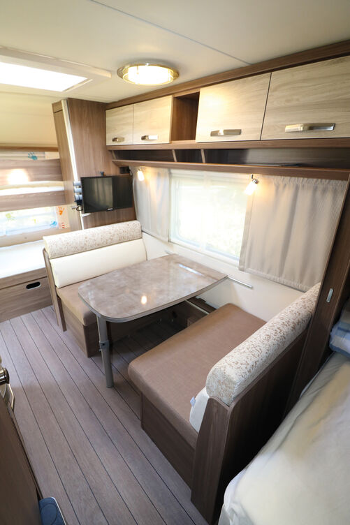 Le décor de mobilier bicolore et les surfaces brillantes du plan de travail et de la table créent une ambiance moderne.