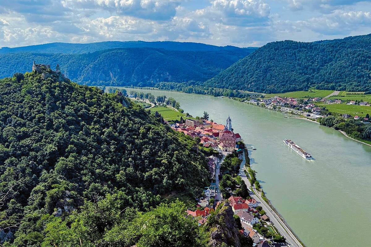 Le décor de carte postale de la Wachau près de Dürnstein, avec son fameux clocher bleu et les ruines de son château fort perché sur un rocher, le tout face au Danube sur lequel navigue paisiblement un bateau de croisière.
