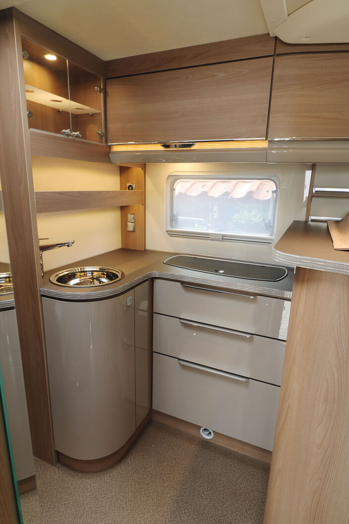 Im winkelförmigen Küchenblock mit dem praktischen Thekenaufsatz ist genug Platz für Kochtöpfe, Geschirr und Vorräte.