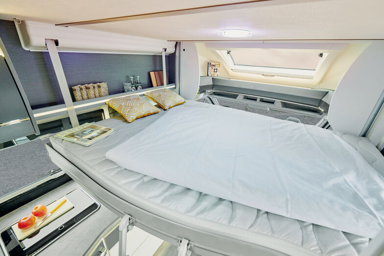 Das elektrisch absenkbare Hubbett über der Lounge-Sitzgruppe.