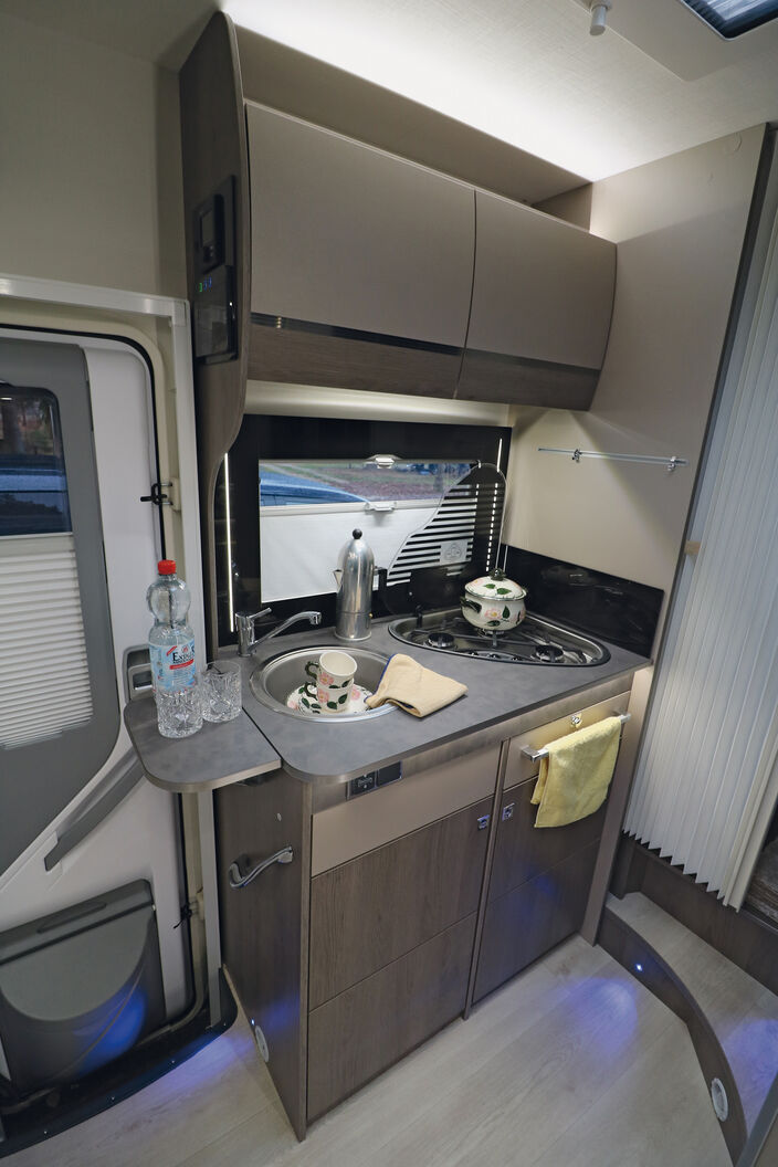 Die kompakte und funktional eingerichtete Küche bietet genug Stauraum sowie vielfältige Lichtelemente.